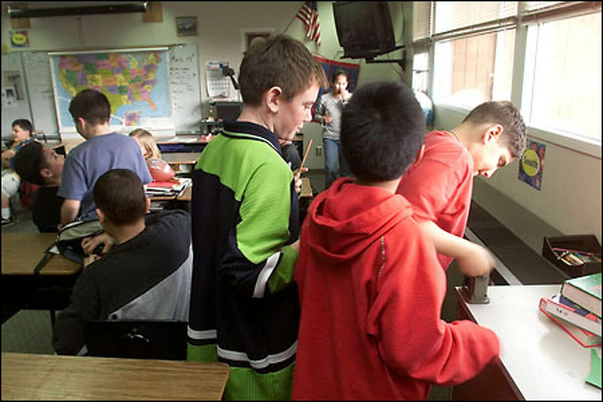 Tayne Wilscam, Jestoni Jimenez and Harold Serrano sharpen pencils in their crowded fifth-grade classroom at Hillcrest Elementary School in Oak Harbor.