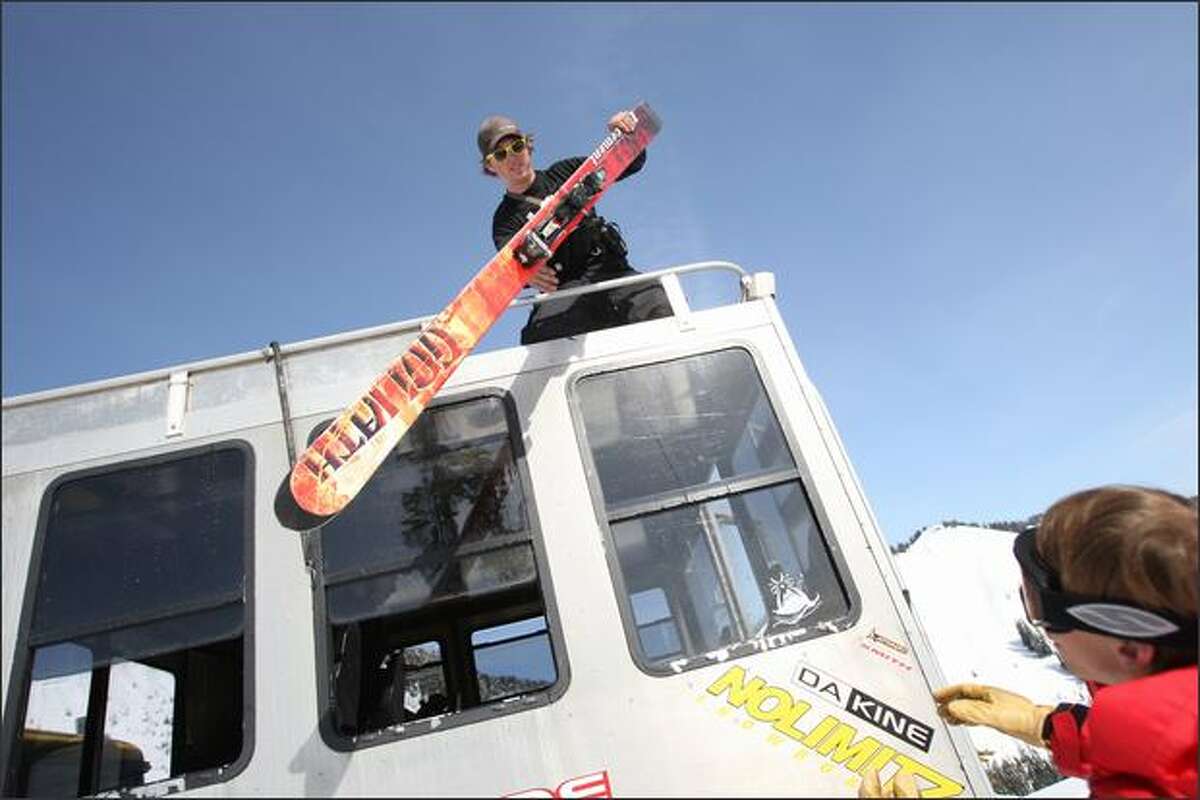 Kyle Foley unloads skis from the snowcat on a trip with Cascade Power Cats near Stevens Pass on March 13.