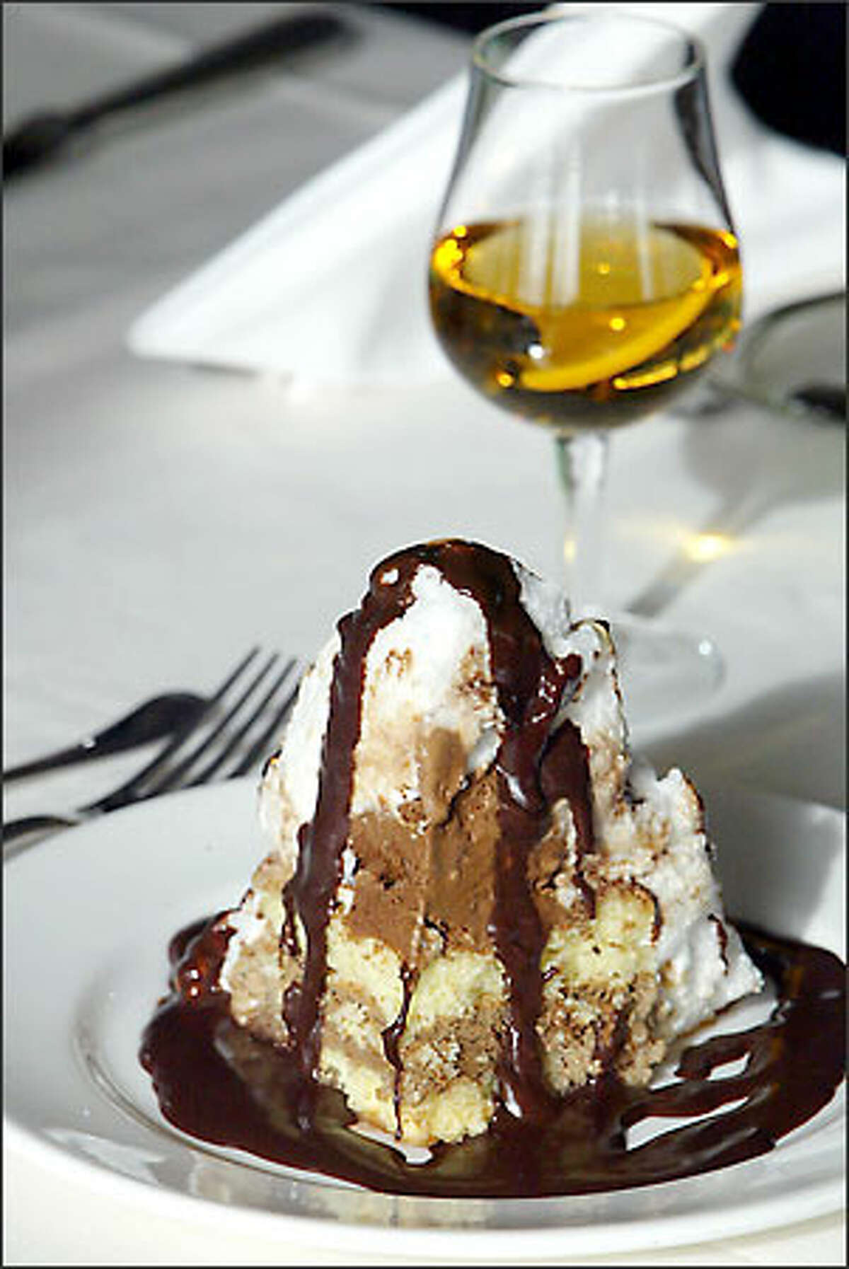 The dessert features liqueur-soaked cake topped with ice cream, meringue and a chocolate or strawberry sauce.