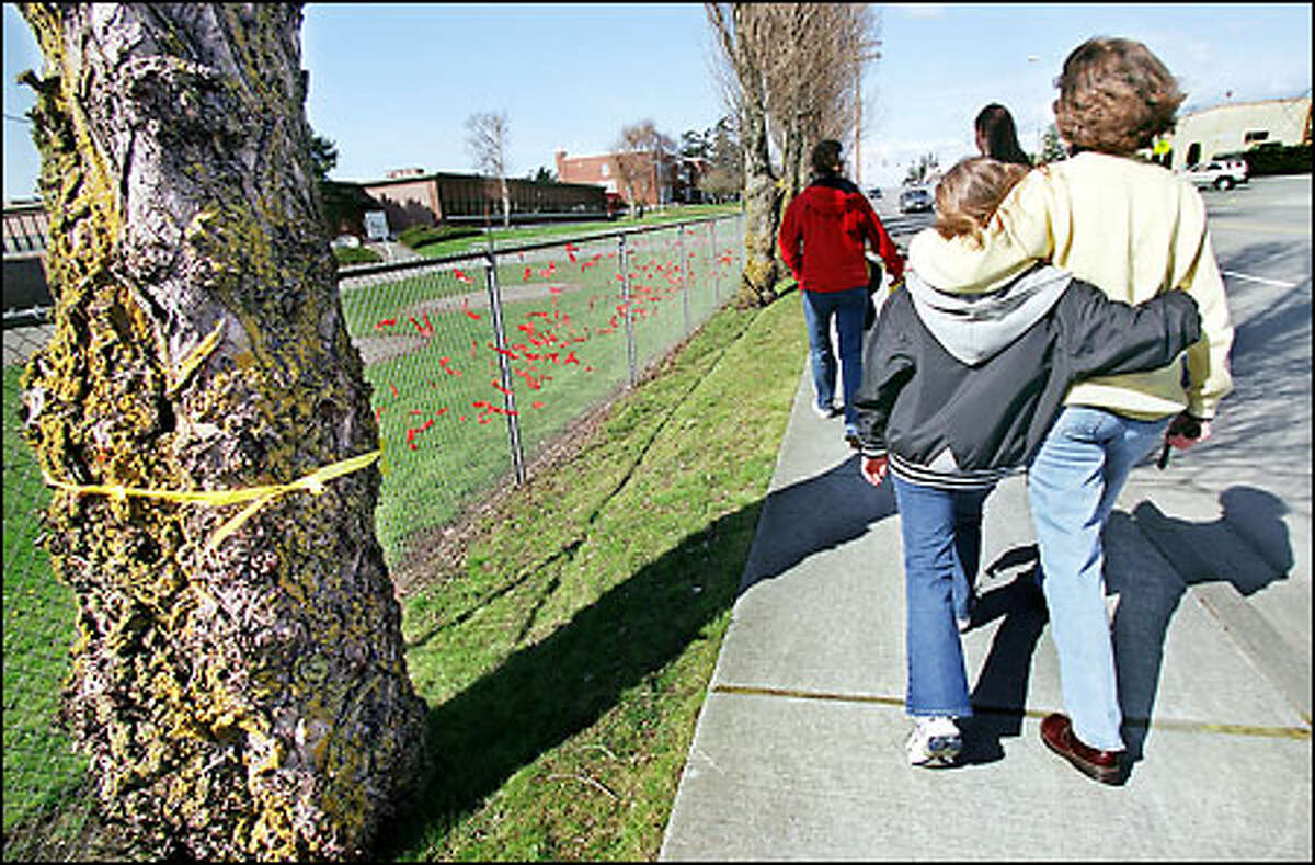 Kim Walter walks with her daughter Bethany, 10, after tying yellow ribbons to trees in Oak Harbor. They were thankful no one from their family was being held in China.