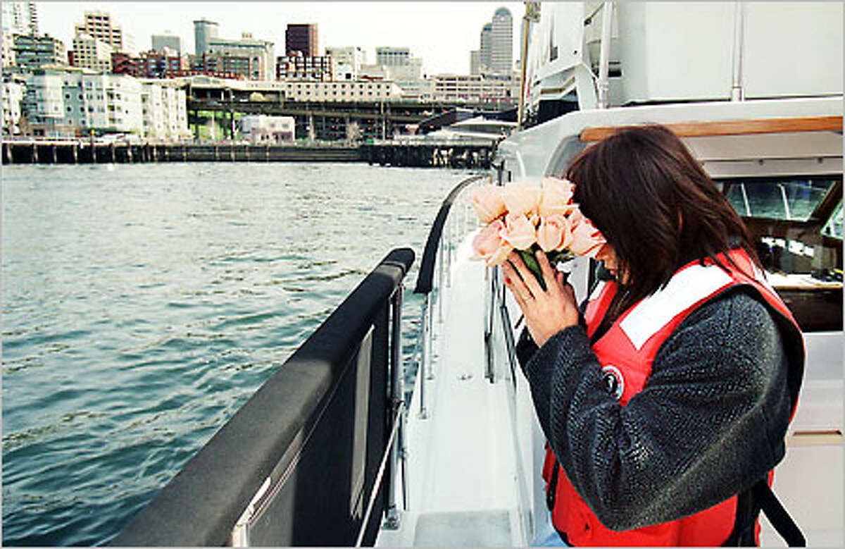 Nanthana Olney prays before dropping flowers into Elliott Bay yesterday in memory of the 15 crew members who perished aboard the Arctic Rose April 2 in the Bering Sea. Nanthana and her husband, Dave Olney, owned the Arctic Rose. Dave's brother Mike Olney perished. Another wreath was dropped in memory of the Titanic sinking 89 years ago yesterday.
