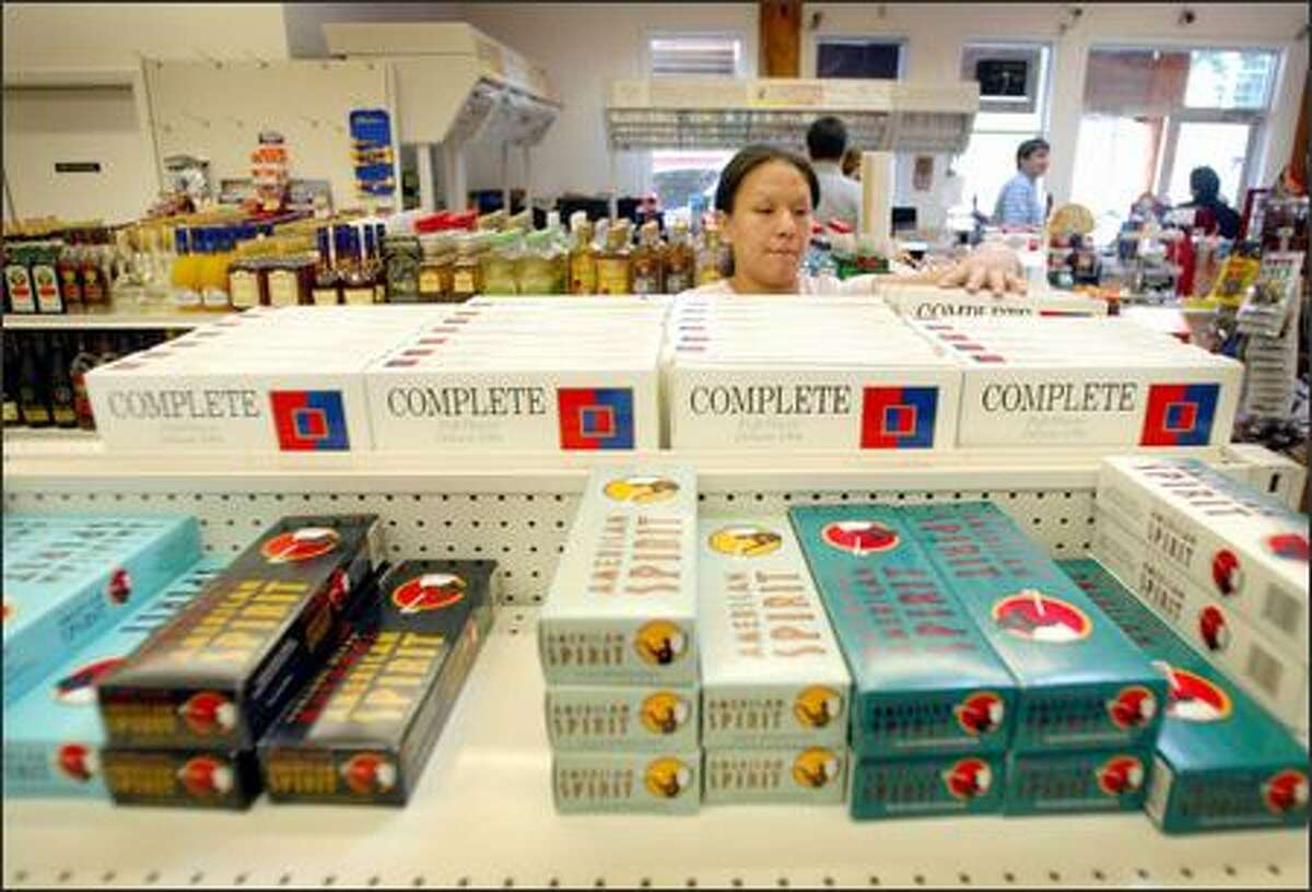 Kristin Penn stocks shelves with Skookum Tobacco's Complete cigarettes at the Kamilche Trading Post. The brand now is made in North Carolina, but production will soon move to the Squaxin Island Tribe's plant near Shelton.