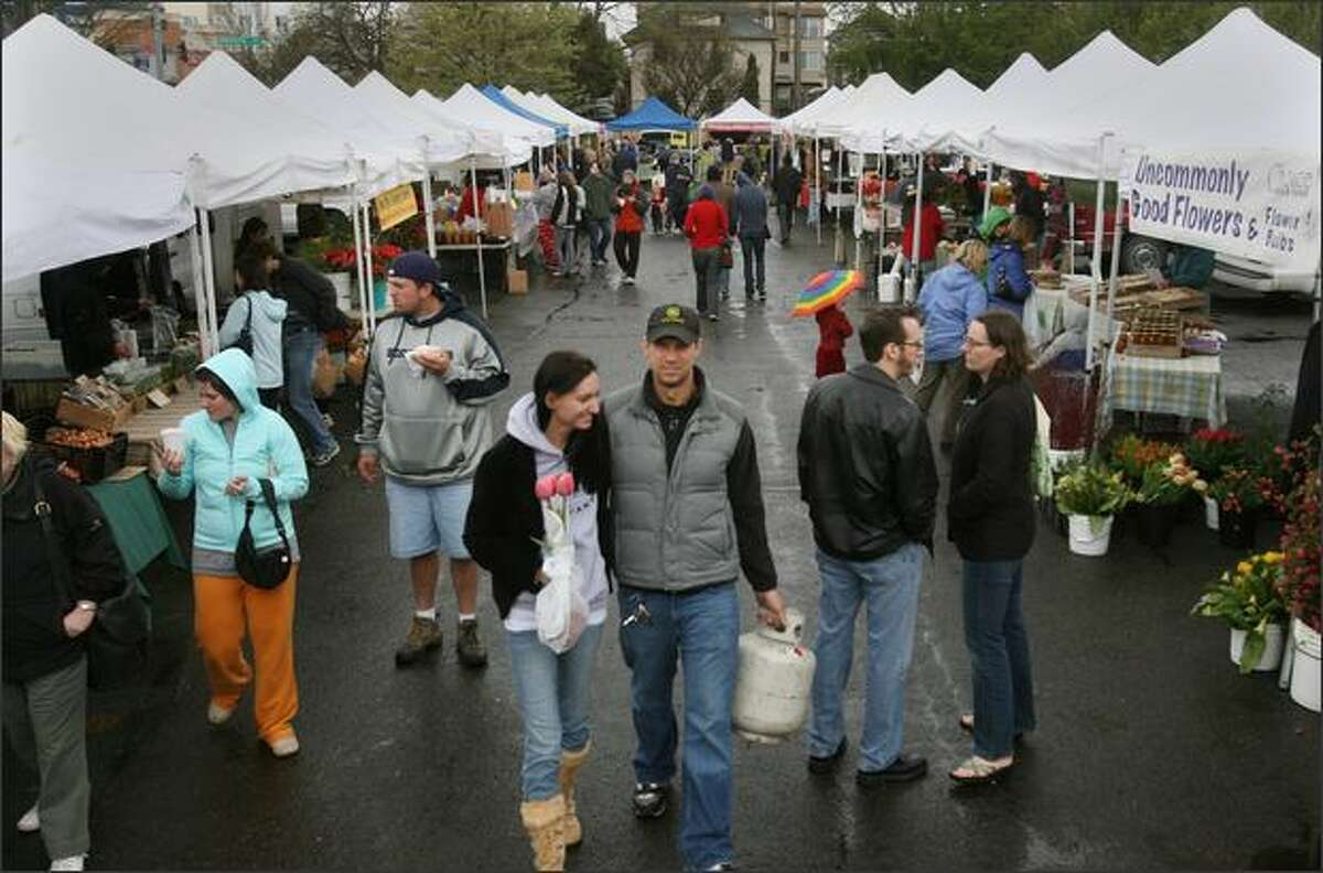 Cold weather and rain Saturday couldn't keep shoppers away from the University District Farmers Market. The need for organic, healthful and local food is real, activists say.