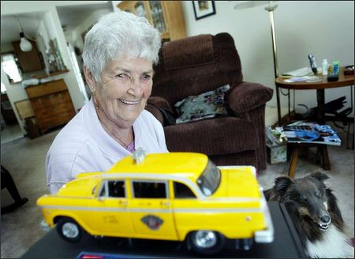 At home in Parkland with her dog Skiddles, Nadine McKee Henry, 85, poses with a reminder of her wartime cab-driving adventure in Seattle. When the war ended, so did her job.