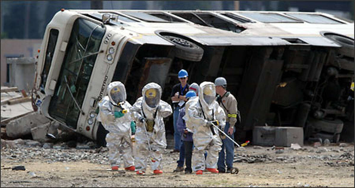 The wreckage of a bus lies in the background as emergency workers respond to an imaginary terrorist attack on Seattle.