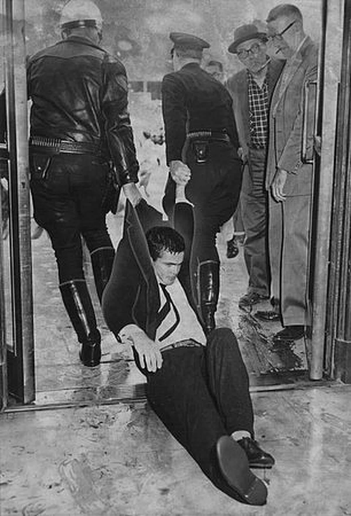 Two police officers drag a protester out of City Hall in San Francisco, one of 64 people hauled off to jail on "Black Friday," May 13, 1960.