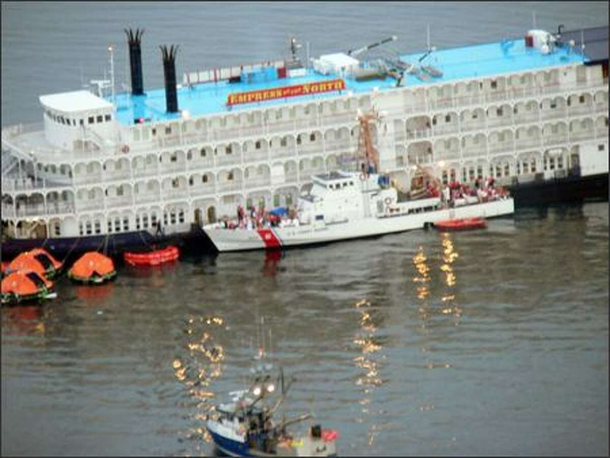 A Coast Guard vessel is shown alongside the grounded Empress of the North cruise ship as passengers are evacuated near Juneau, Alaska. (AP Photo/United States Coast Guard)