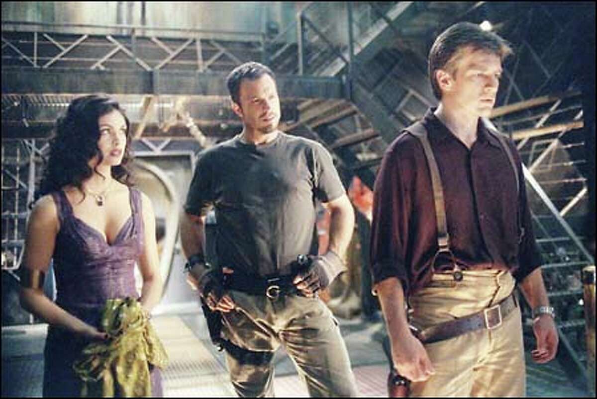 Morena Baccarin as Inara, Adam Baldwin as Jayne and Nathan Fillion as Captain Malcolm "Mal" Reynolds in the new Fox science-fiction adventure series "Firefly."