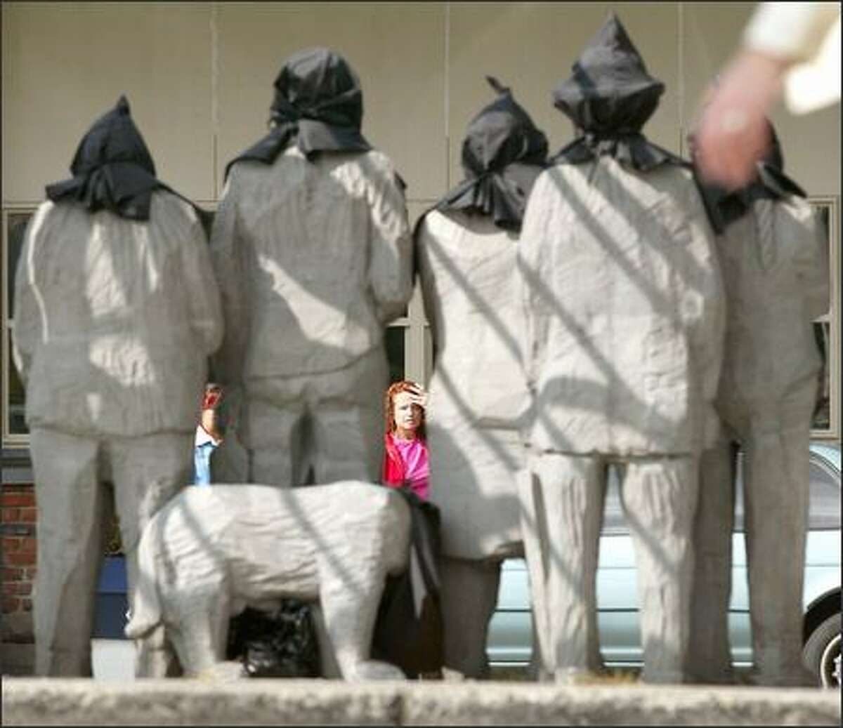 The figures in Fremont's "Waiting for the Interurban" sculpture were hooded yesterday, a reference to the recent prison-abuse photos from the war in Iraq.