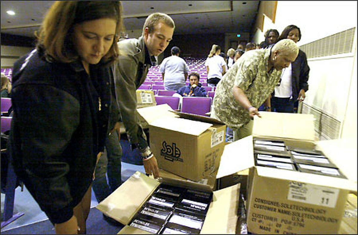 Janie Hendrix, sister of Jimi Hendrix, and Andrew Reynolds, a world-renowned skateboarder, help Garfield High School girl’s basketball coach Joyce Walker pass out shoes to Garfield students. More than 100 pairs of shoes were donated to the school by Emerica Shoes, which sponsors Reynolds. In exchange, Reynolds will use Hendrix’s song “Burning the Midnight Oil” in his video.