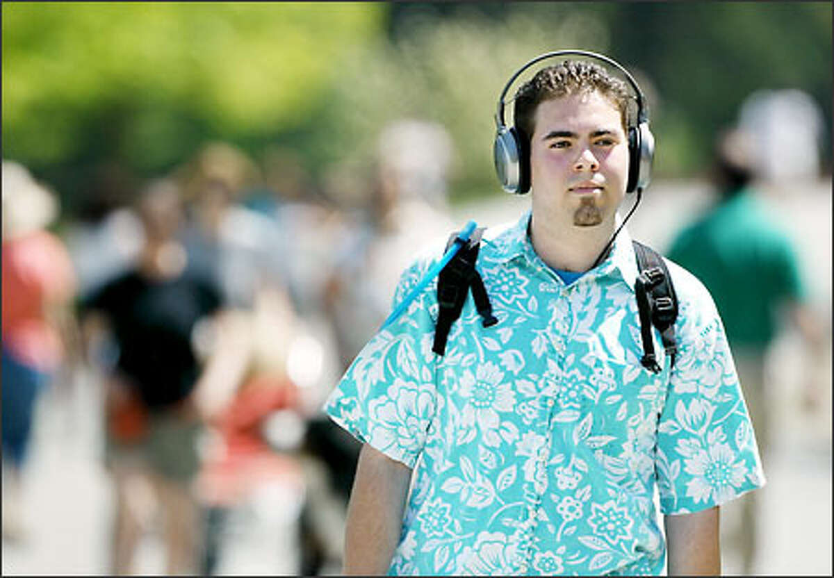 Walking around Green Lake yesterday, massage student Mike Larios, 20, listens to music he downloaded from the Internet on his new minidisc player.