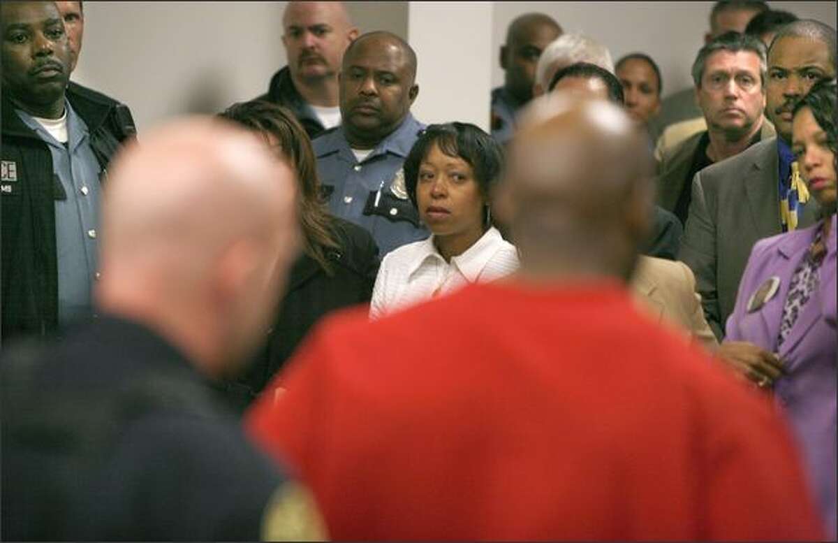 Cheryl Terry, center, the widow of Seattle Police Officer Antonio Terry, watches as Quentin Ervin is led away from a King County courtroom after being sentenced for her husband's killing. At right is Yvonne Terry Jones, the officer's sister. "Today, we are finally done being victims," Cheryl Terry said at the emotional .