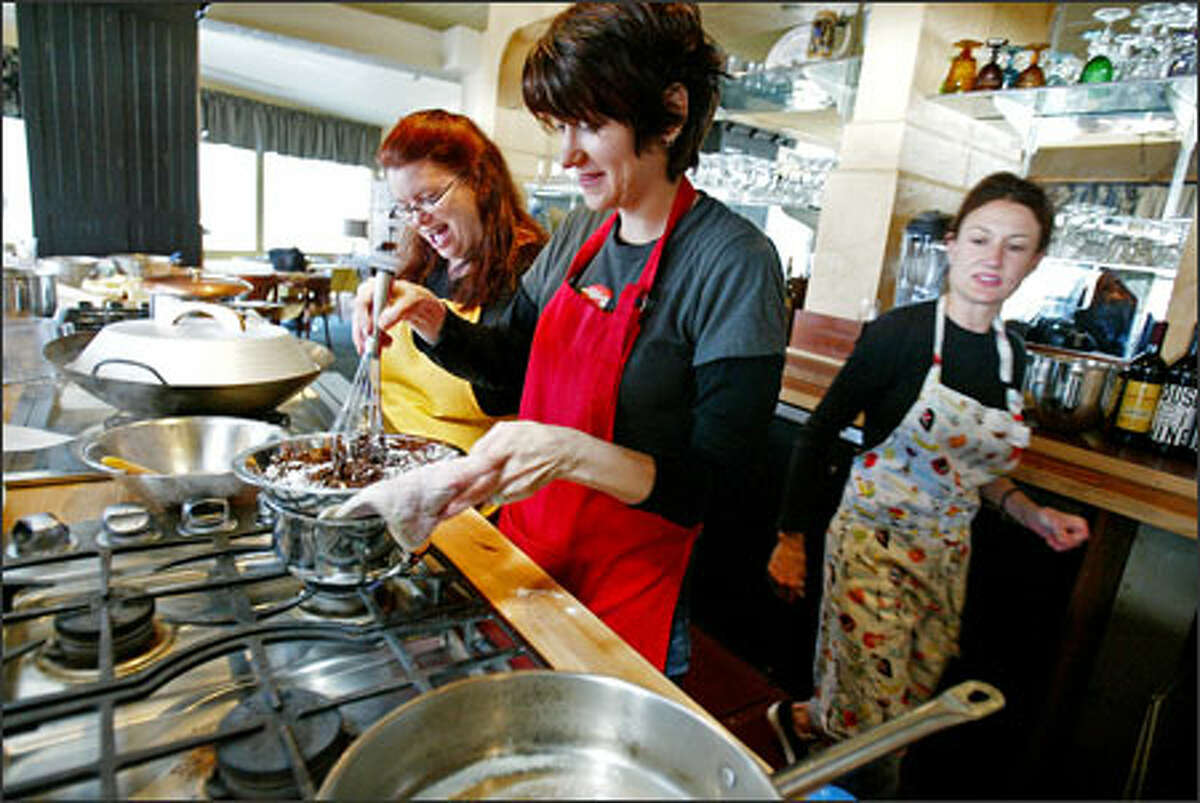 D. Parvaz, center, heats ingredients for a Chocolate Decadence recipe in a class at the Blue Ribbon Culinary School with Traca Savadogo at her side. Parvaz calls herself "the ultimate culinary reprobate," but she survived the six-week program and learned to cook a little.