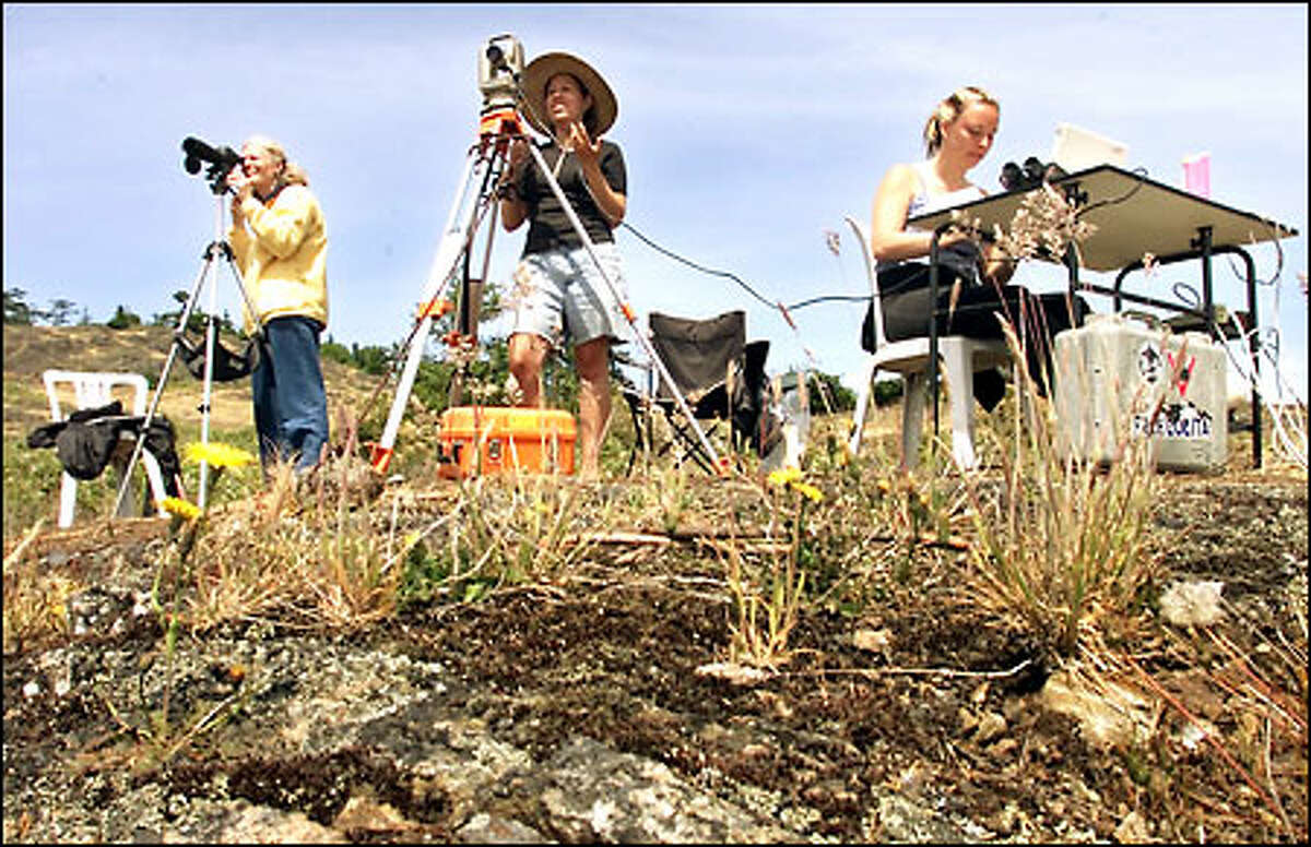 Whale researchers Jodi Smith, center, and Jessica Grady, right, use survey gear and a computer to plot the positions of orcas and their proximity to whale-watching boats in the San Juan Islands. At left is Astrid van Ginneken.