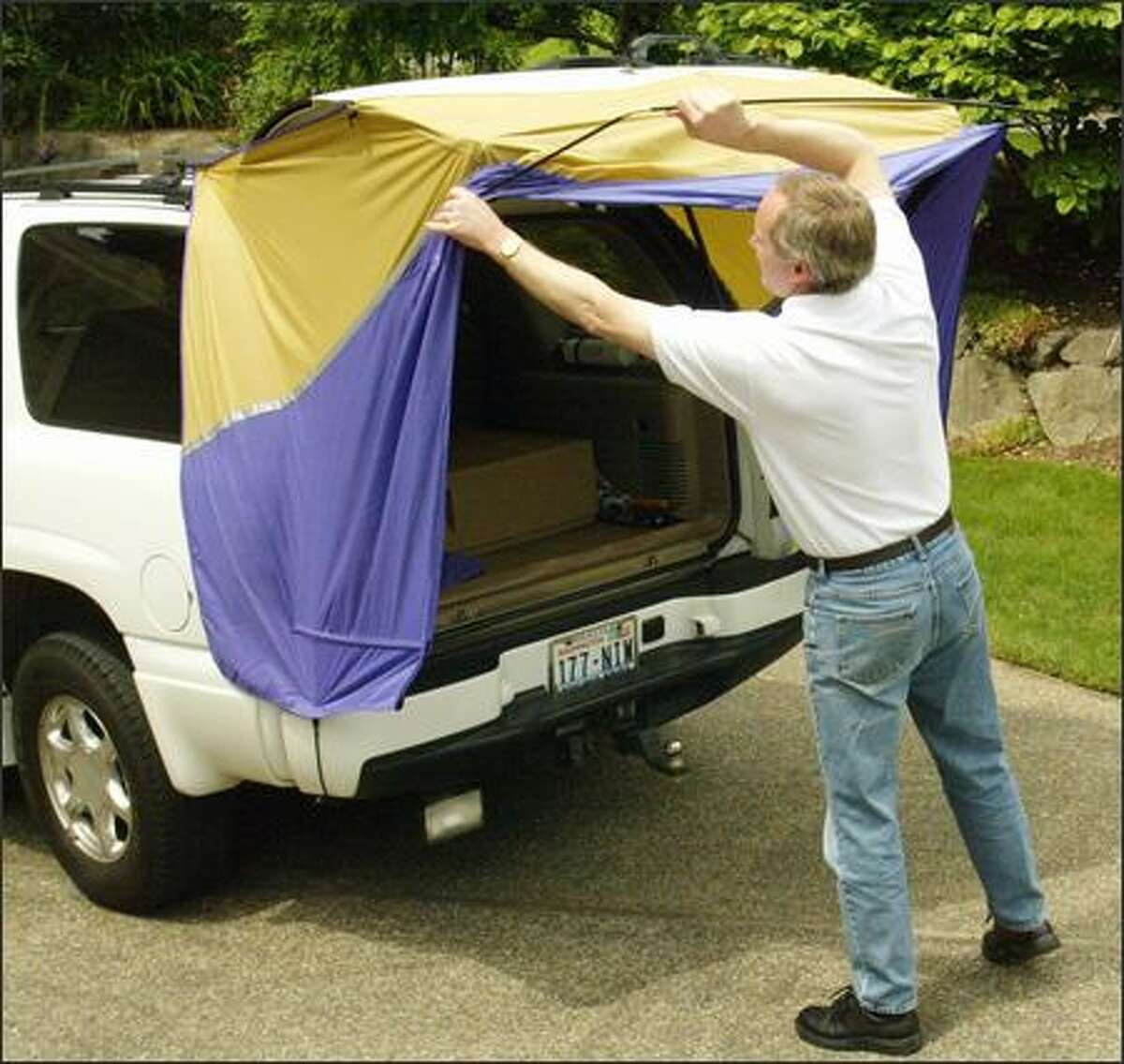 Bill Christenson, co-owner of Bumperchute along with his wife, Renee, sets up one of the portable canopies on a vehicle's back end. Now in their second year of operation, the Christensons have already cracked one key market: emergency vehicles.