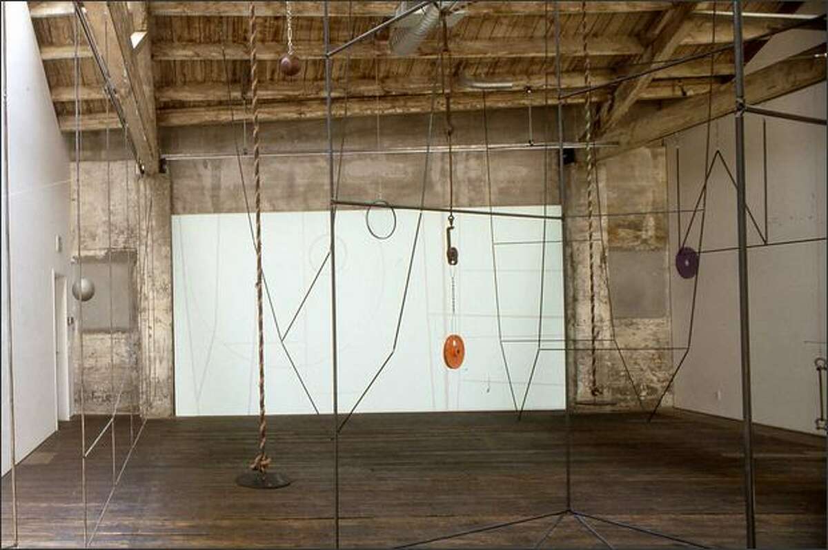 In Carolyn Healy and John Phillips' installation, interlocking metal rods become rectangles, triangles and the graceful fall of two diagonals, with cables, ropes, weights and pulleys. Steel shades dominate with a scattering of brighter shades. (EDUARDO CALDERON)