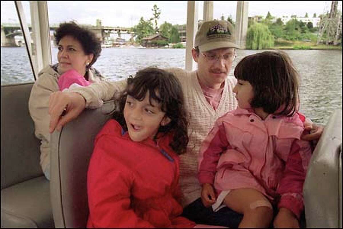 A family from Los Angeles enjoys sights around Lake Union from inside a "duck." David Russell holds Gabriela as his other daughter, Angelica, and wife, Diana, look over the water.