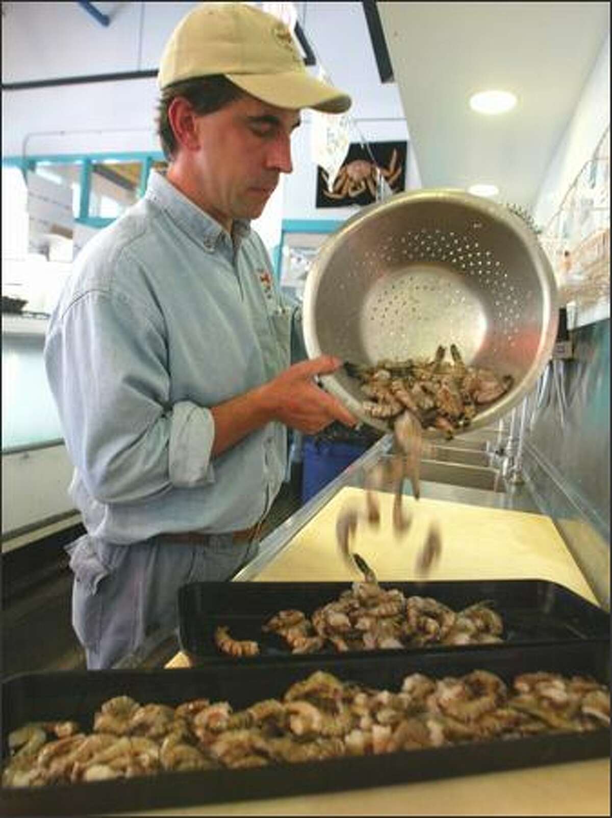 Jon Speltz, of the Wild Salmon Seafood Market at Fishermen's Terminal, prepares Vietnamese prawns for display.