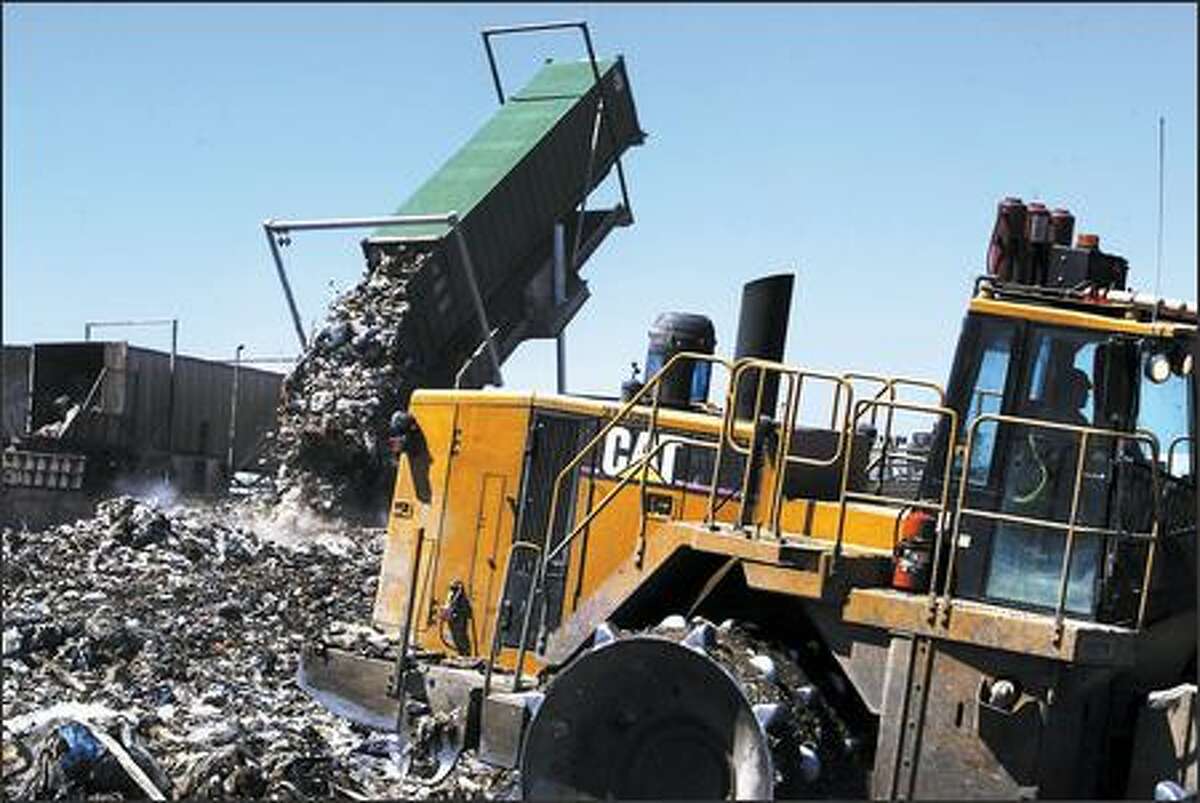 Container 980377, containing trash from the 600 block of Northwest 76th Street in Seattle, is emptied into the Waste Management landfill as bulldozers spread the garbage evenly near Arlington, Ore. After the area is full, it will be covered with soil and grass.