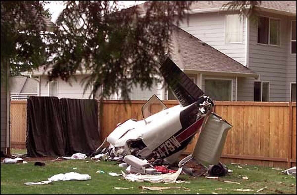 The wreckage of a small plane lies in the back yard of a home in Puyallup, a little more than a mile from the end of the runway at Pierce County Airport.