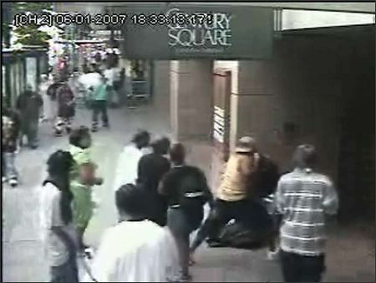 A security camera captures the June 1 beating of a man outside the Century Square building near Third Avenue and Pine Street by a group of youths. The man was hospitalized, then released. (SEATTLE POLICE DEPARTMENT)
