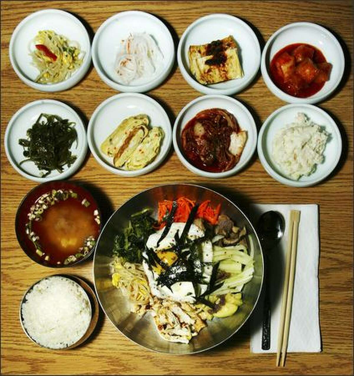 Four Seasons Korean Restaurant offerings include bibimbob, bottom, with julienne carrots, bean sprouts, beef, egg and rice, along with eight appetizers and a bowl of miso soup.
