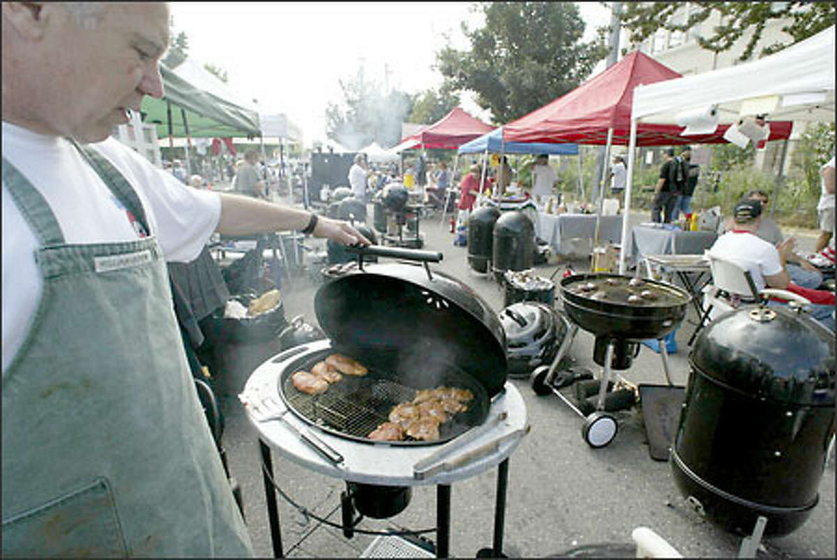 Alan Dujenski of Bulldog BBQ checks the progress of his chicken at the Low & Slow "Light" BBQ Northwest Championship in the University District Saturday. Dujenski took first place in the produce category. The event was sponsored by the Seattle Post-Intelligencer.