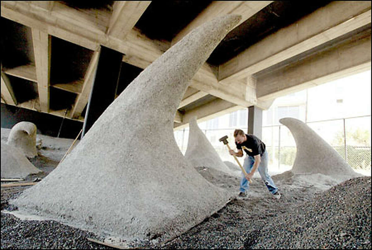 Michael Graham, a carpenter for Pacific Studios, works on installing "Wave Rave Cave" under the state Route 99 viaduct at the corner of Western Avenue and Bell Street in Seattle.