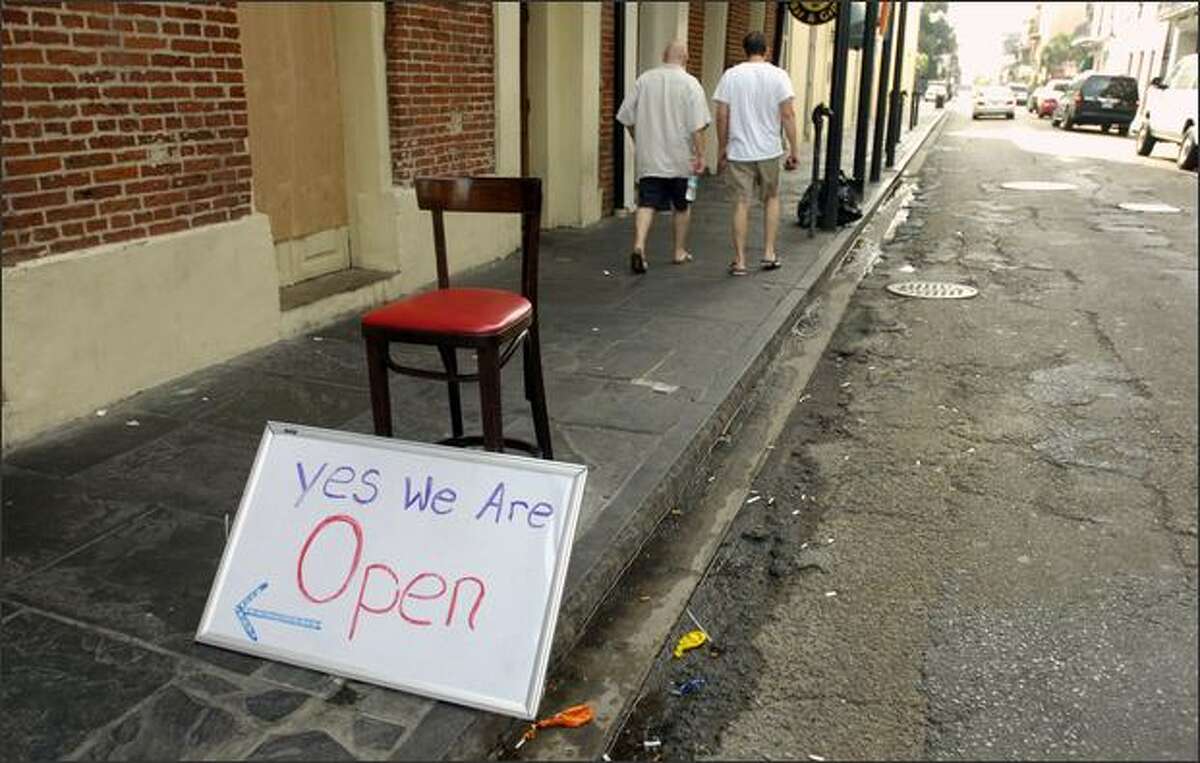 Residents walk in the French Quarter after eating breakfast at one of the few business open Sunday, a day before forecasters predict Hurricane Gustav will make landfall near New Orleans, Louisiana. According the National Hurricane Center Gustav was downgraded to Category 3 with top winds near 125 mph early Sunday. Forecasters expected it to regain strength later in the day.