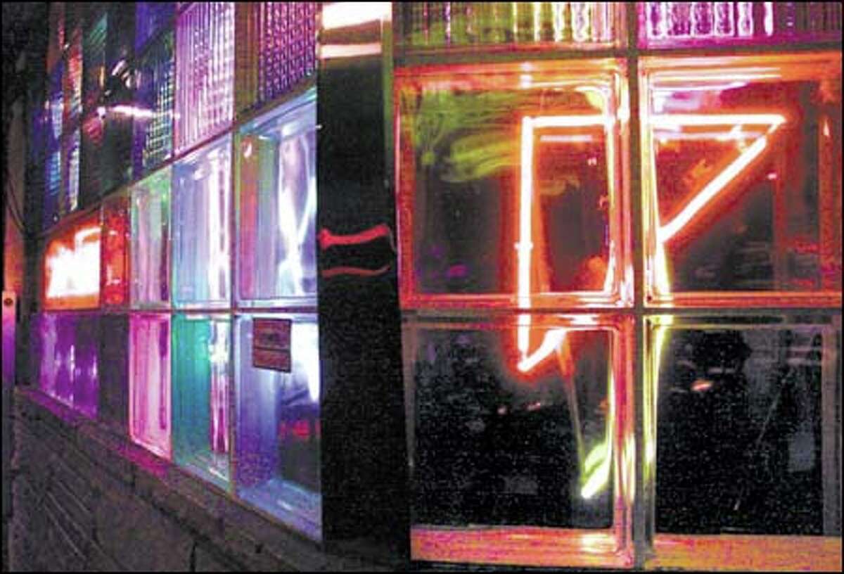 Neon lights show through thick glass bricks at the Mecca Cafe at 526 Queen Anne Ave. N. Purists may decry such visual and commercial pollution, but neon signs can distinguish one city from thousands of others.
