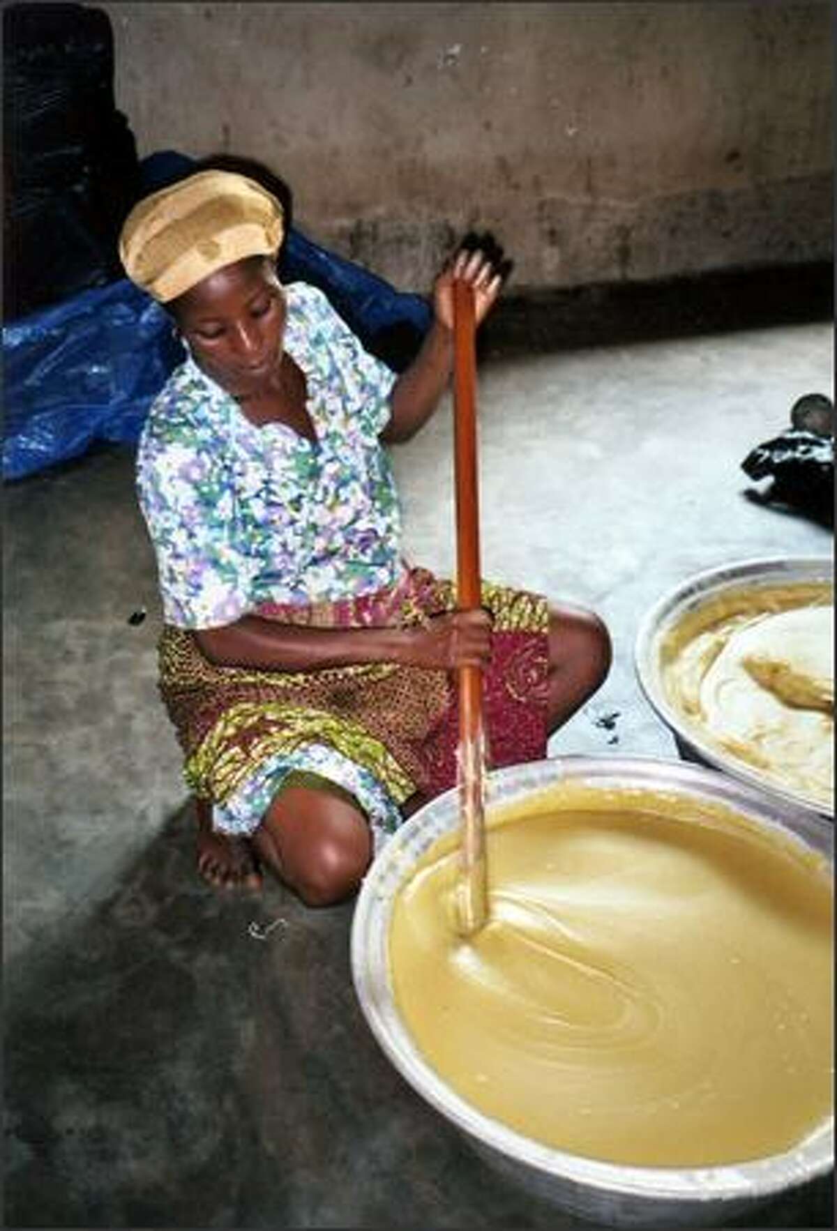 A worker at Alaffia's co-op in Togo stirs the cooked, whipped shea butter during the final stage of a 12-step process.