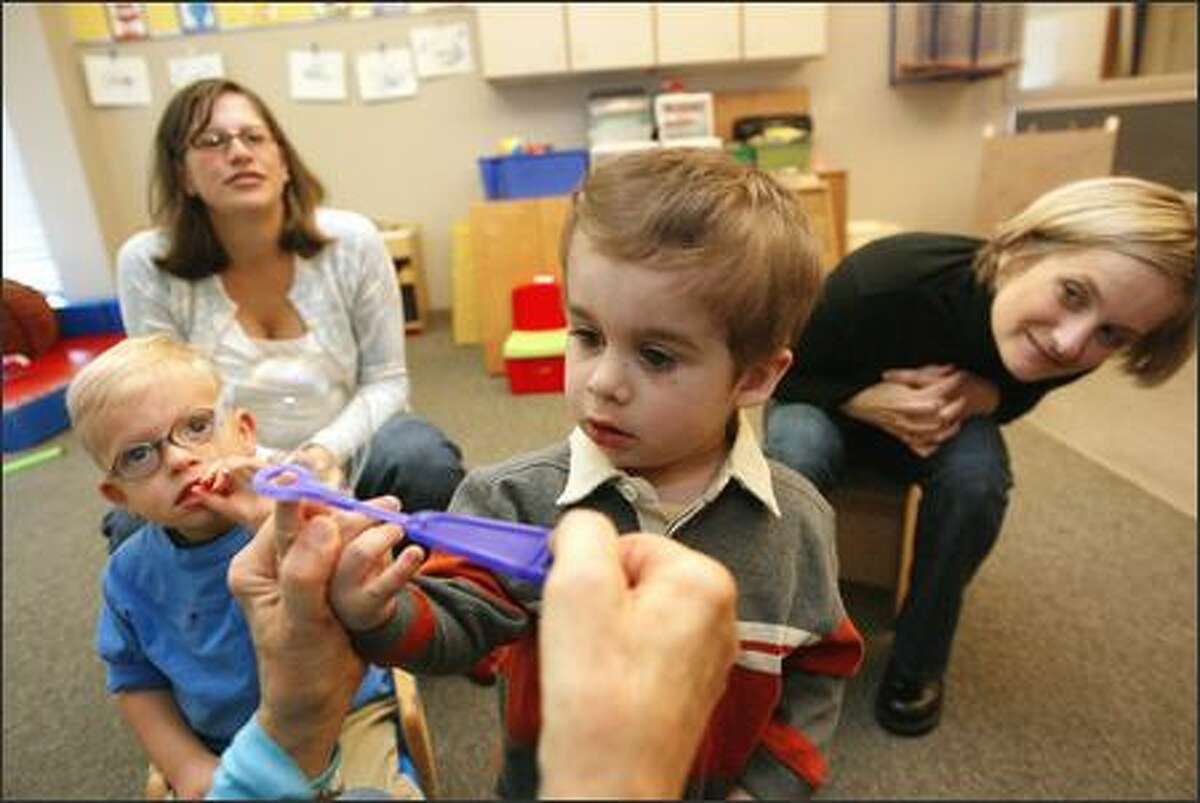 Nikola Radmanovic, 2, pops a bubble as his mom, Aleksandra Markanovic, right, watches during a Boyer Children's Clinic class. William Acker, 2, and his mom, Anne, watch.