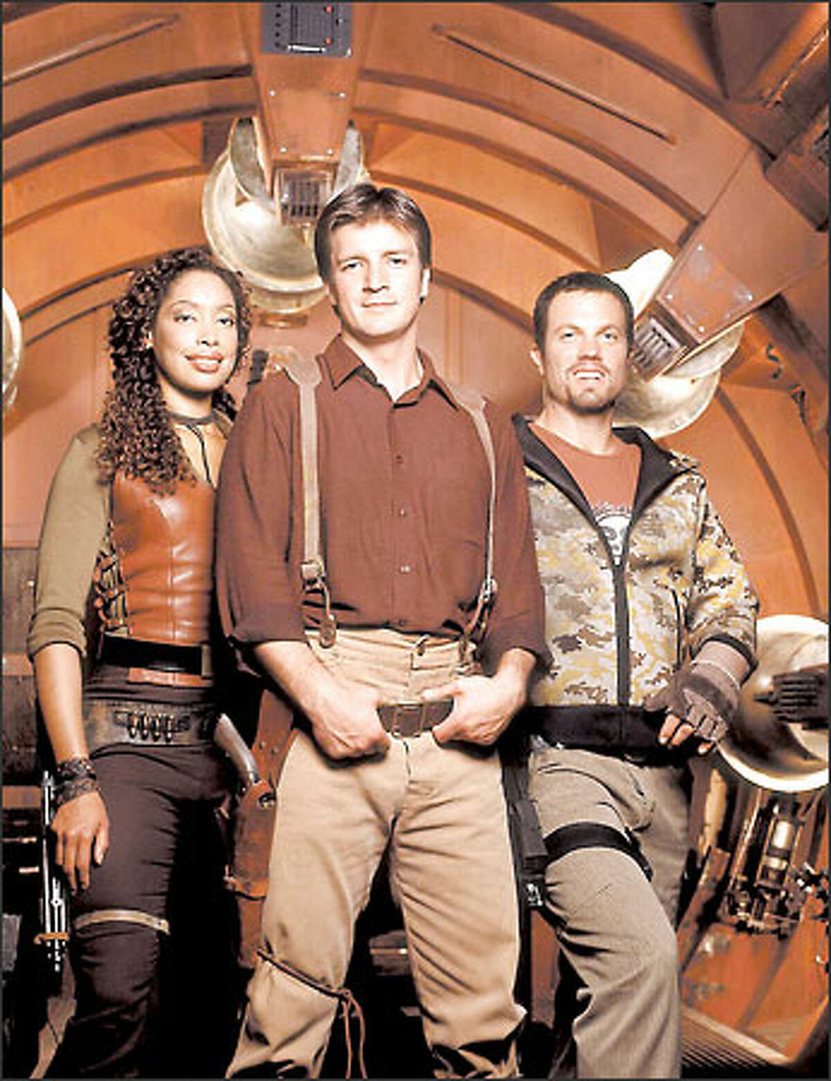 In Fox's "Firefly," Gina Torres, left, Nathan Fillion and Adam Baldwin play characters surviving by their wits on a spaceship.