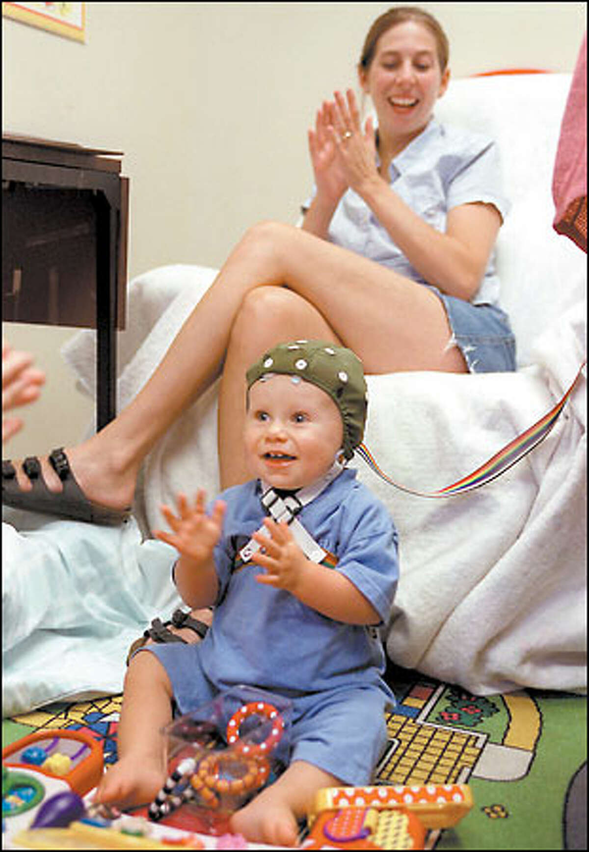 Samuel Dodd, 11 months, gets ready to participate in an event-related experimental session at the University of Washington to study speech perception. Behind him is his mom, Janine Dodd of Auburn.