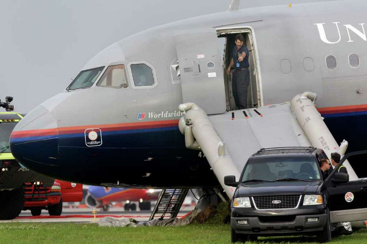An official looks out from the doorway of a United Airlines airplane that made an emergency landing shortly after takeoff at Louis Armstrong International Airport in Kenner, La., Monday, April 4, 2011. The United Airlines flight from New Orleans to San Francisco returned to the New Orleans airport within minutes of taking off Monday after rocking back and forth. (AP Photo/Patrick Semansky)