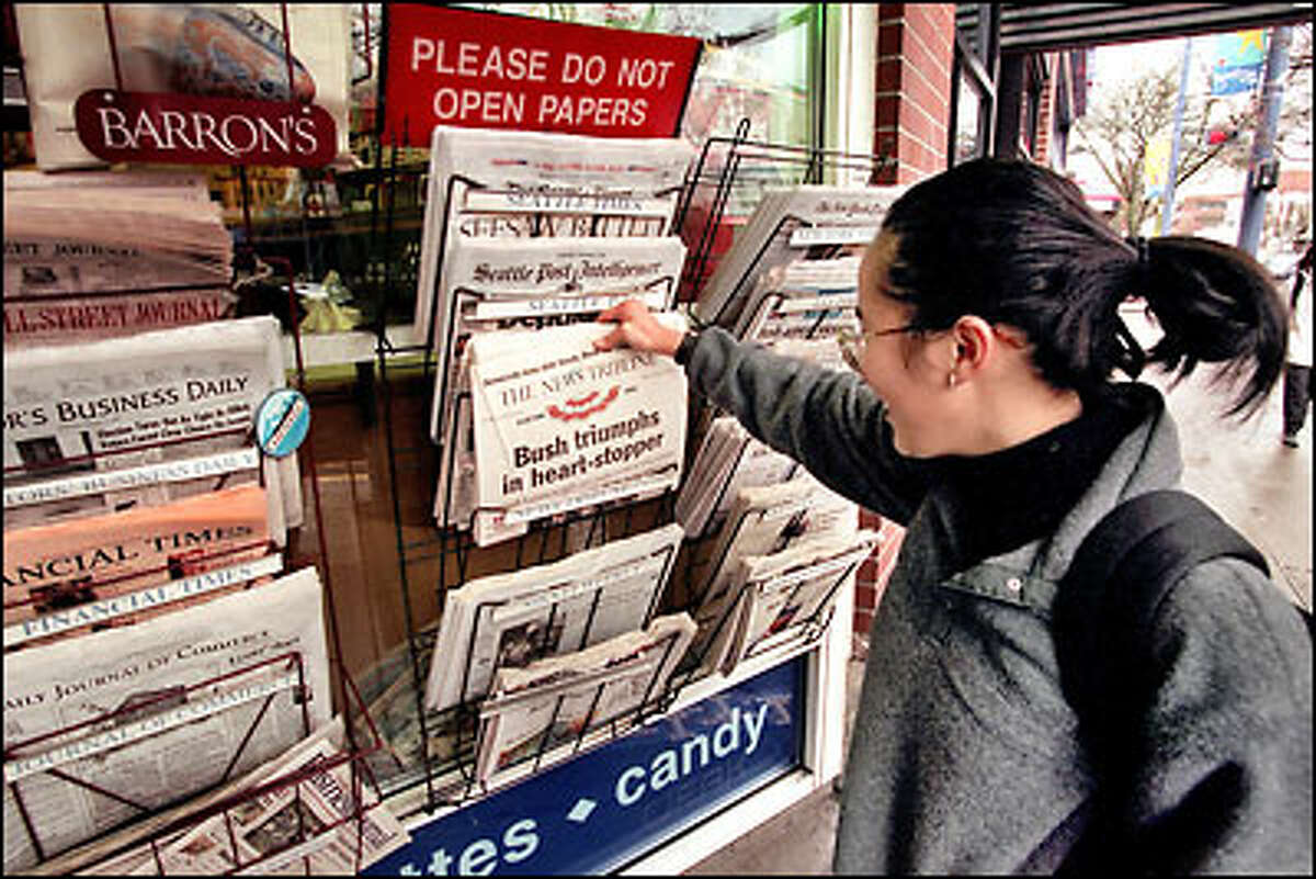 Joy Andrada laughs as she reads the headline in Tacoma's The News Tribune yesterday at the Broadway News stand.