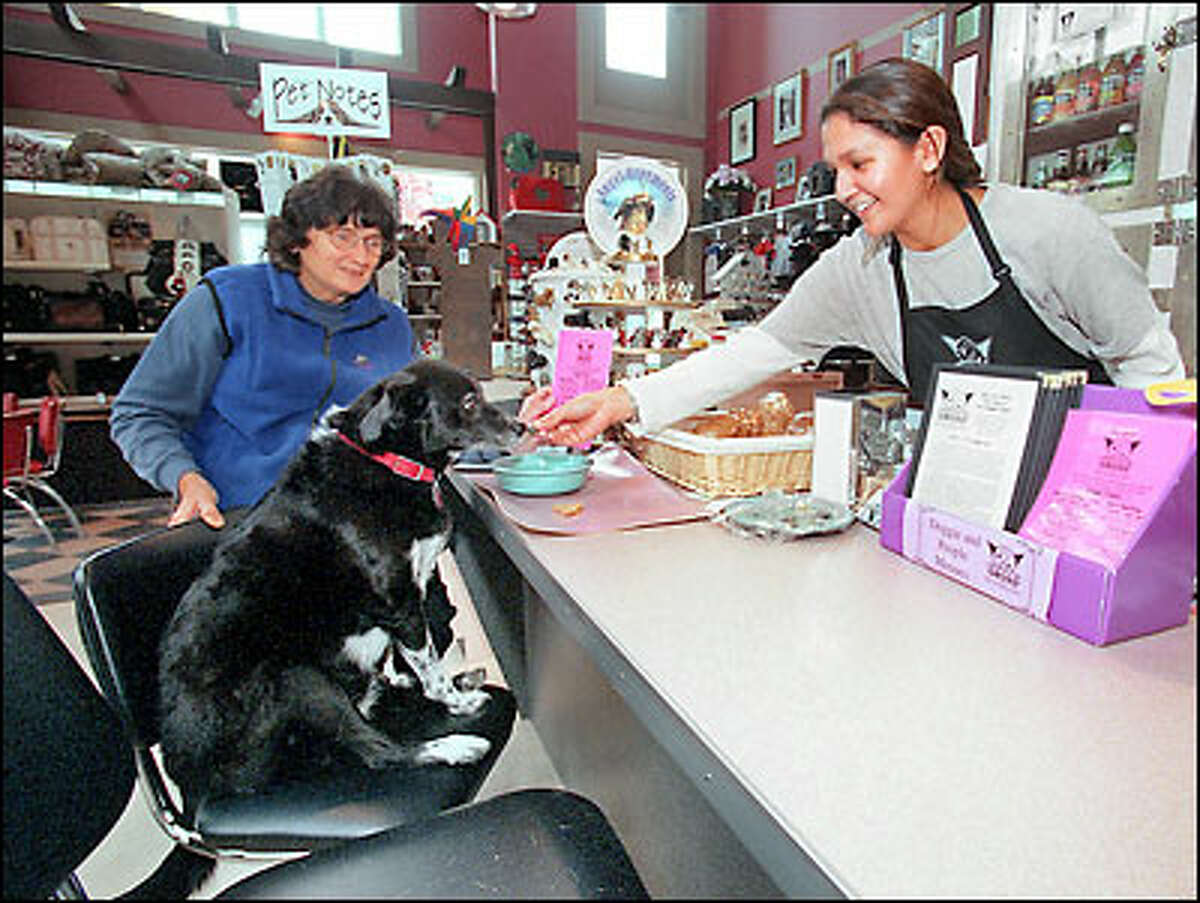 Ann Melton and her dog, Gypsy Girl, are served by Concha Brionez at the Doggie Diner. The pet restaurant also does birthday parties.