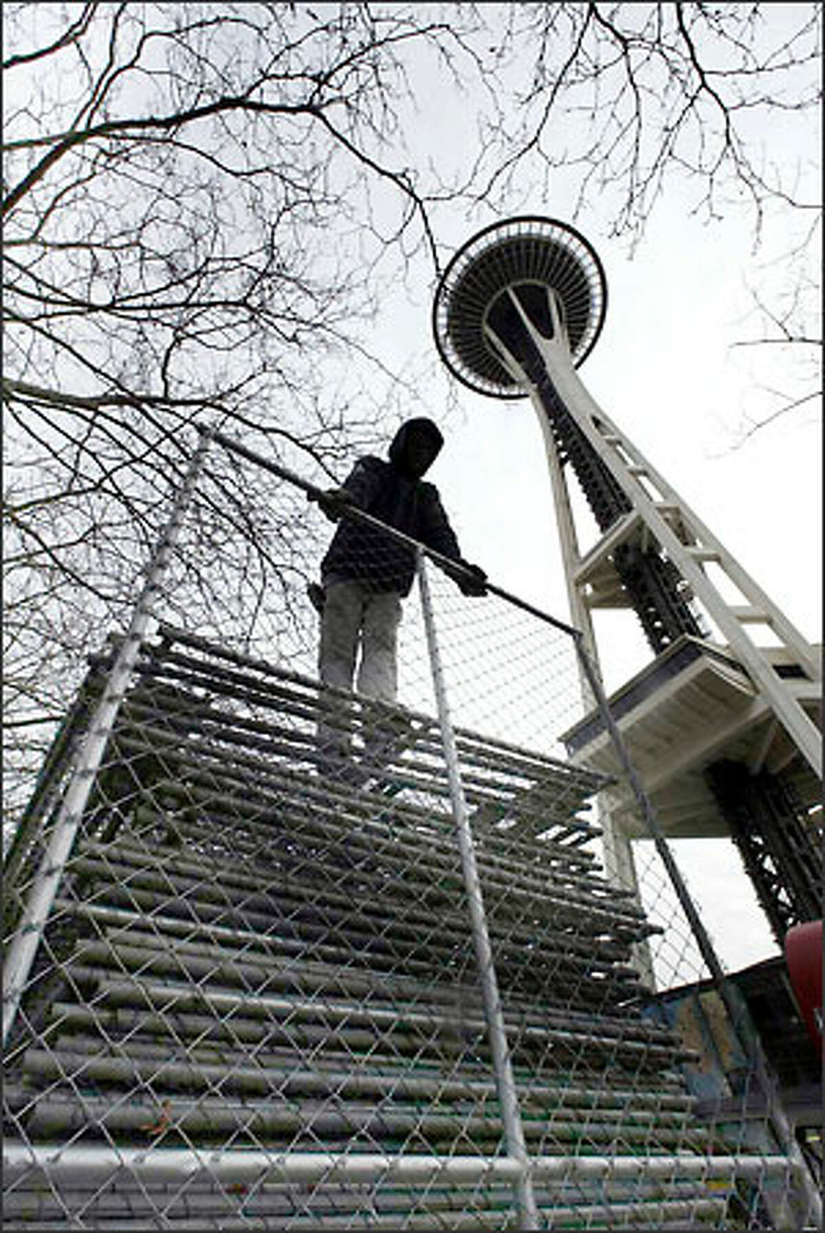 Victaly Soloneko from National Rent-a-Fence unloads sections of chain link that will form a security fence line around the Space Needle for New Year's Eve.