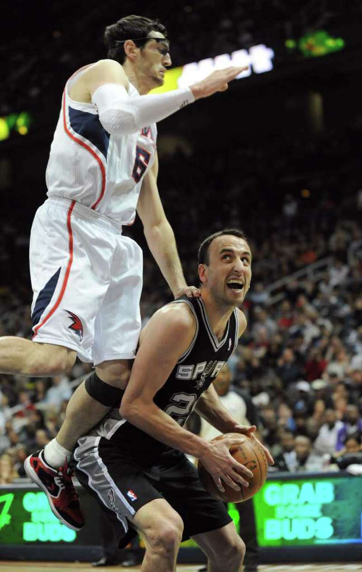 Atlanta Hawks guard Kirk Hinrich, left, commits a flagrant foul on San Antonio Spurs guard Manu Ginobili, of Argentina, in the second half during an NBA basketball game Tuesday, April 5, 2011, in Atlanta. The Spurs defeated the Hawks 97-90.