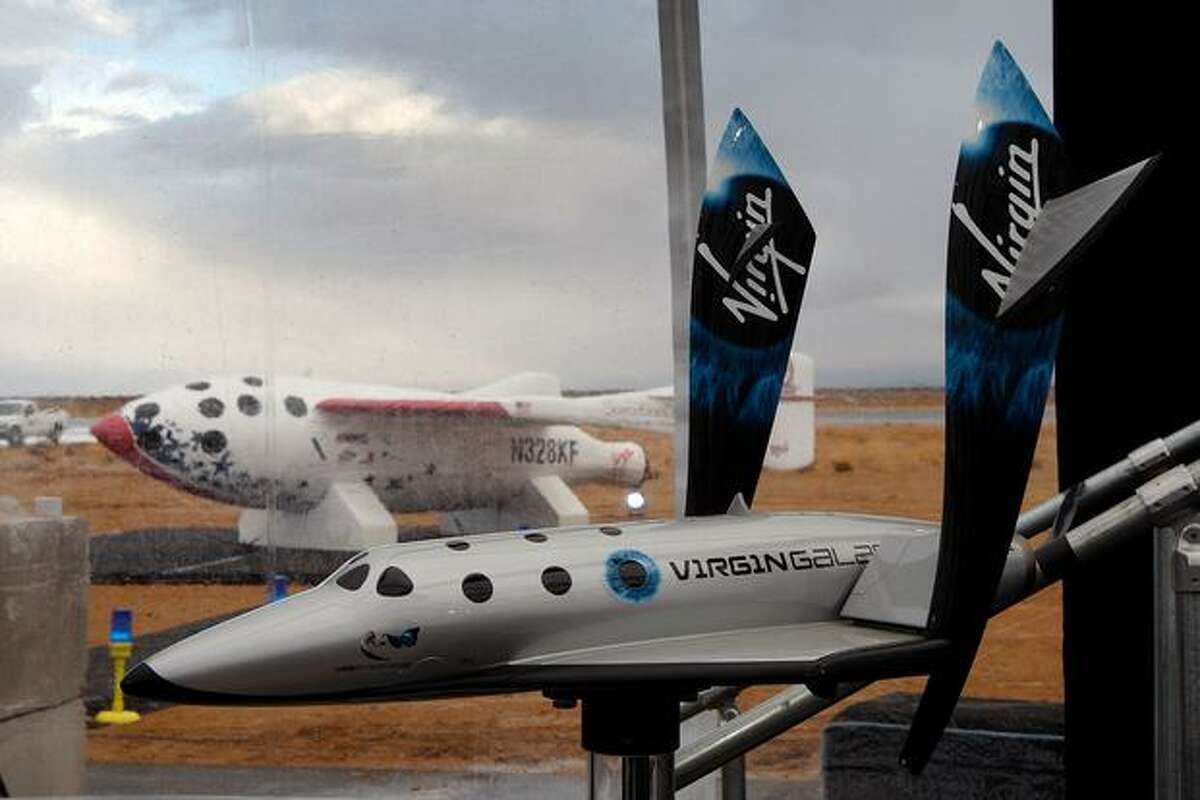 MOJAVE, CA - DECEMBER 7: A model of SpaceShipTwo is seen with the original SpaceShipOne visible outside as Virgin Galactic unveils its new SpaceShipTwo spacecraft at the Mojave Spaceport on December 7, 2009 near Mojave, California. The eight-person VSS Enterprise, named after the Star Trek ship of the same name, is the first of a series of space-planes for customers of Virgin Galactic who have paid around $200,000 for a suborbital flight into space. British entrepreneur Sir Richard Branson is financing the spacecraft and aerospace designer Burt Rutan is building it through The Spaceship Company, a joint venture of Scaled Composites and Virgin Group. (Photo by David McNew/Getty Images)