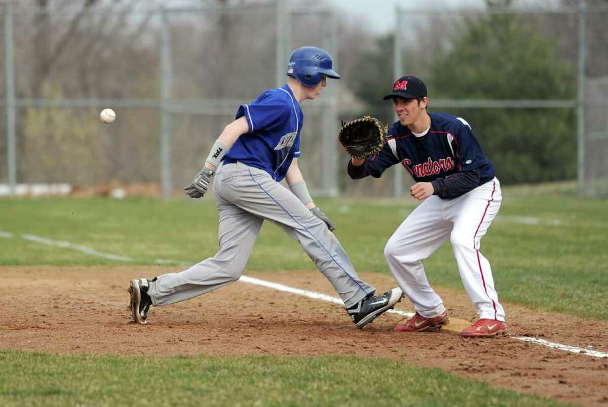 Fairfield Ludlowe's Dylan Grande runs safely back to first as McMahon's Aleko Petridis reaches for the ball during Wednesday's game at Brien McMahon High School on April 6, 2011.