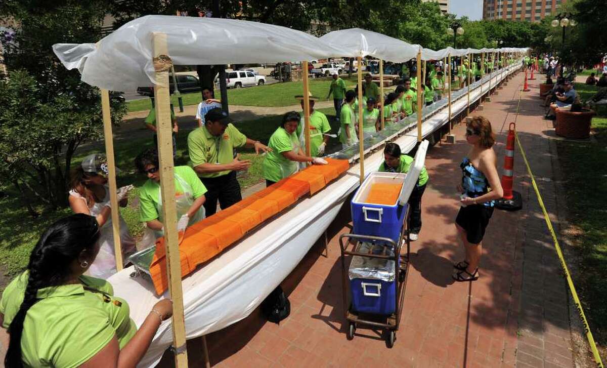 Tortillas are distributed as volunteers construct an enchilada that weighs over 1.5 tons at Milam Park on April 9, 2011. The enchilada was a collaboration of 20 local restaurants and the Rey Feo Consejo Foundation.