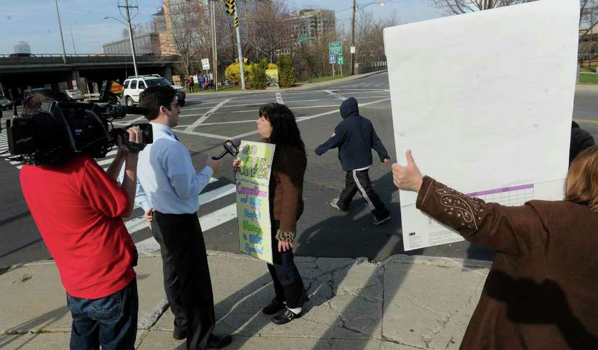 Protester Mara Miller, center, of Fairfield, speaks to the media at the entrance to the Hilton Stamford Hotel along Greenich Avenue and South Broad Street in Stamford, Conn. on Saturday April 9, 2011. She was with about 12 other people protesting U.S. House Speaker John Boehner who is the keynote speaker at the 2011 Prescott Bush Awards Dinner, which is being held at the hotel.