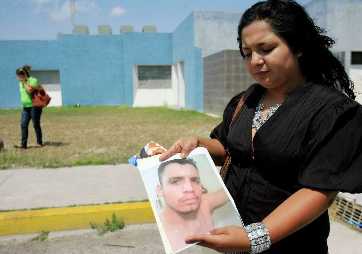 Matamoros, Tamaulipas - 9 Apr 2011 - Rebecca Cruz Camacho, right, holds a photo of her brother Moises Cruz Camacho, who has been missing for a year outside of the Tamaulipas Attorney General's Office Forensic Medical Service Center in Matamoros on April 9, 2011. Photo by Gabe Hernandez