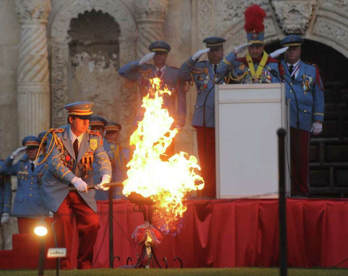 The outgoing King Antonio, Nick Campbell, lights a flame in Alamo Plaza as the new King Antonio, Bill Mitchell, stands at the podium during a ceremony on Saturday evening. April 9, 2011. King Antonio, one of the longest-standing Fiesta traditions, is a member of the royalty who reign over the merriment of Fiesta. BILLY CALZADA / gcalzada@express-news.net