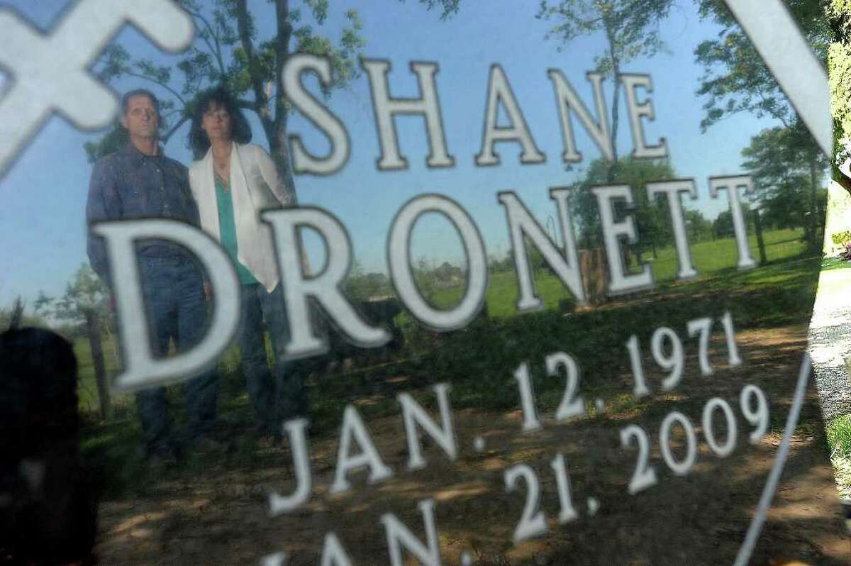 Shane Dronett's mother, Candace Henry, and his stepfather, James Breeden, stand at the late football player's grave. Guiseppe Barranco/The Enterprise