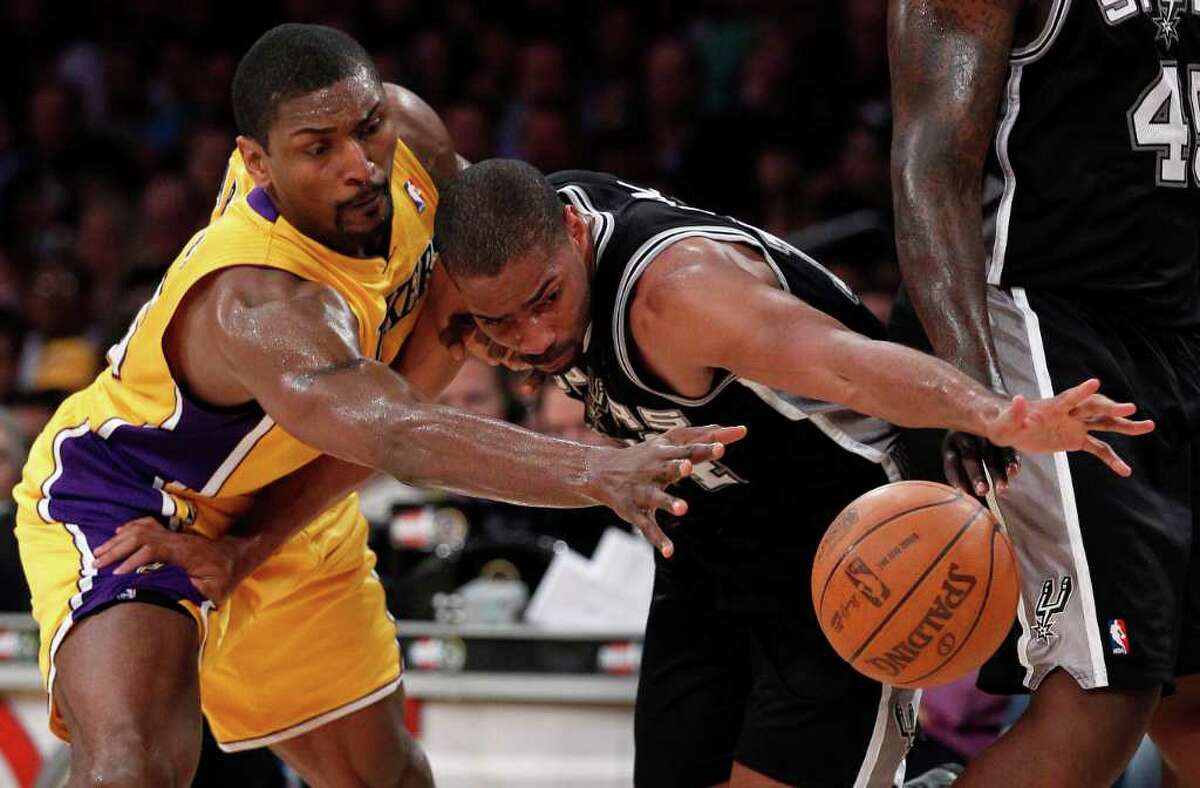 Los Angeles Lakers' Ron Artest, left, battles San Antonio Spurs' Gary Neal for a rebound during the second half of an NBA basketball game in Los Angeles, Tuesday, April 12, 2011.