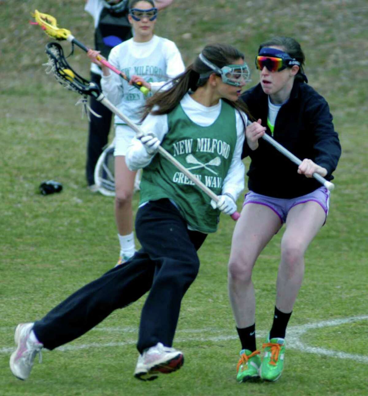 SPECTRUM/Cristina Munoz of New Milford High School girls' lacrosse has teammate Olivia Monteiro on her toes during a pre-season drill as Destinee Carey checks out their technique. April 2011