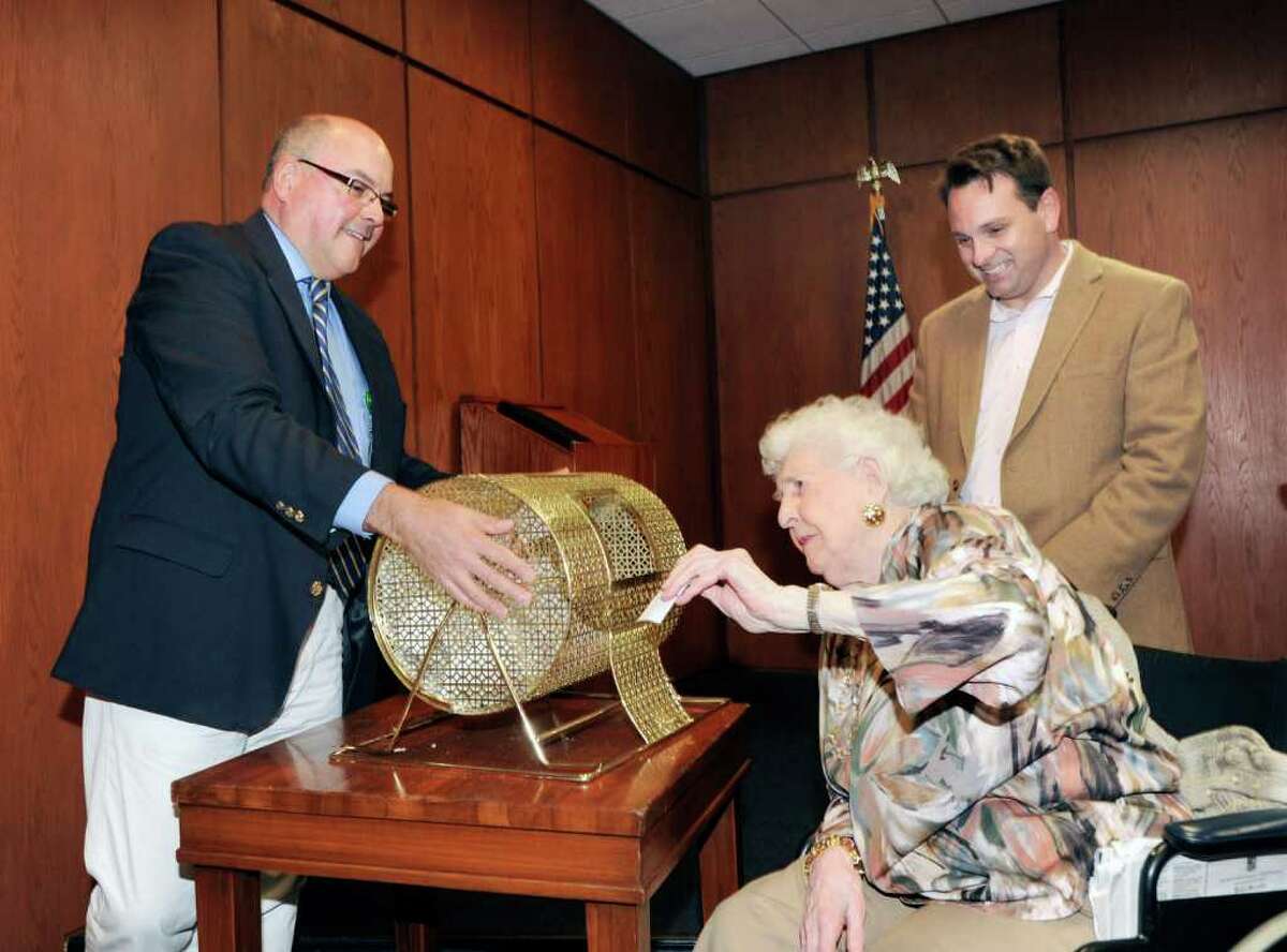 Nathaniel Witherell nursing home resident 96-year-old Helen Weisner draws the winning raffle ticket on behalf of the Greenwich Police Silver Shield Association during Regis Philbin Day at Greenwich Town Hall, Friday afternoon, April 15, 2011. The prize was four VIP tickets to the ABC television show “Live! With Regis and Kelly”. At left is Scott Neff, director of The Friends of Nathaniel Witherell, and at right is Greenwich Selectman Drew Marzullo.
