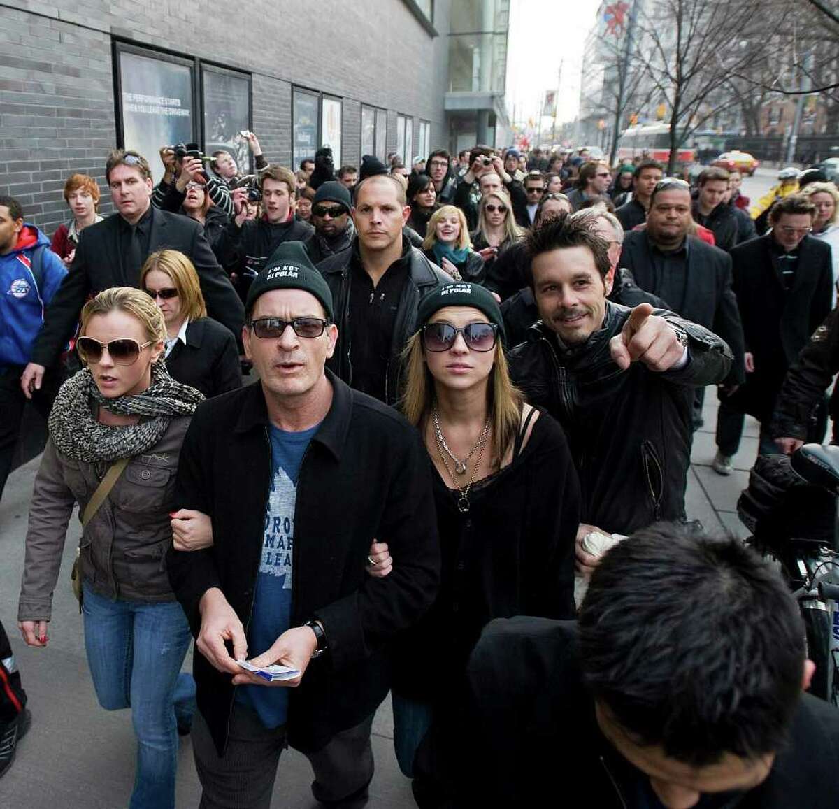 Charlie Sheen is seen walking through downtown Toronto with his angels and a group of his fans on the way to the second night of his Violent Torpedo of Truth tour, Friday, April 15, 2011 at Massey Hall in Toronto